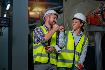 Male and Female Industrial Engineers smile on chiller plant room background.