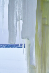 Detail of broken icicle next to frozen lake