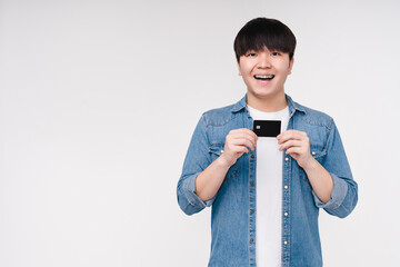 Impressed smiling young asian man korean boy holding showing credit card for loan, cashback, online...