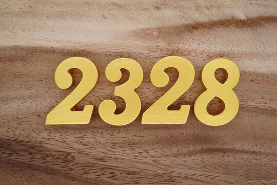 Golden Arabic numerals on a real brown and white wooden floor number 2328