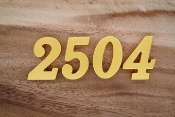 Golden Arabic numerals on a real brown and white wooden floor number 2504