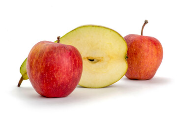 Still life with cut pear and two red apples on a white background