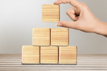 Hand stacking wooden cubes on table with copy space for input wording and infographic icon.