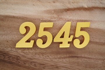 Golden Arabic numerals on a real brown and white wooden floor number 2545