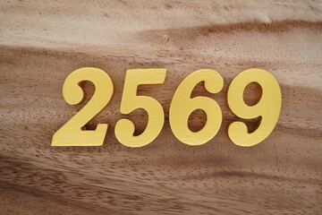 Golden Arabic numerals on a real brown and white wooden floor number 2569