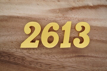 Golden Arabic numerals on a real brown and white wooden floor number 2613