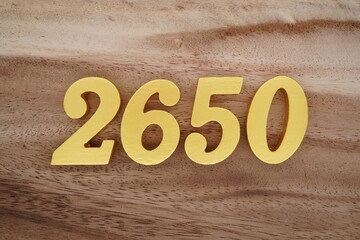 Golden Arabic numerals on a real brown and white wooden floor number 2650