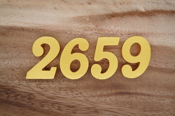 Golden Arabic numerals on a real brown and white wooden floor number 2659