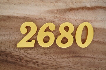 Golden Arabic numerals on a real brown and white wooden floor number 2680