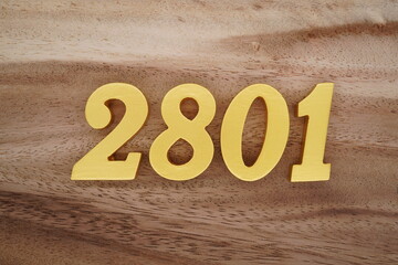 Golden Arabic numerals on a real brown and white wooden floor number 2801