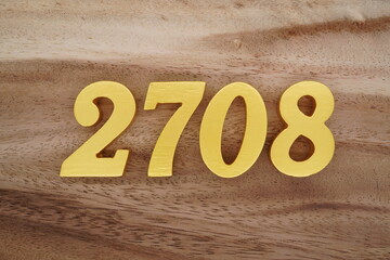 Golden Arabic numerals on a real brown and white wooden floor number 2708