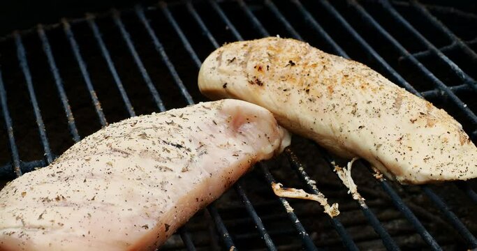 Chicken breast on BBQ being seasoned 
