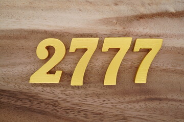 Golden Arabic numerals on a real brown and white wooden floor number 2777