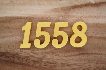 Golden Arabic numerals on a real brown and white wooden floor number 1558