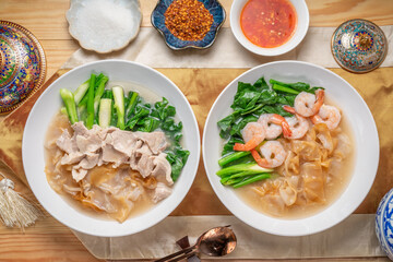 Shrimp Wide Rice Noodles and Pork Wide Rice Noodles with  kale in Gravy Sauce  Served with condiments, chili powder , chili sauce and sugar. Asian food.