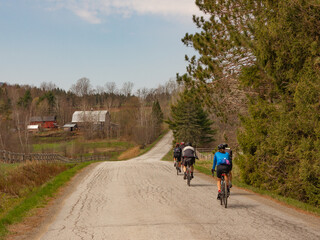 Obraz premium a group of cyclist doing gravel bike in a nice countryside road on a sunny day during spring time