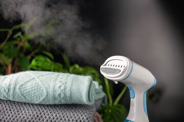 Portable home and travel garment steamer for clothes. Clothes pile. Housework
