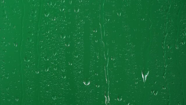 Water rainfall, rain drops falling on window glass over chroma key green screen