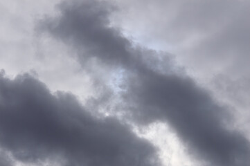 Fototapeta premium The round disk of the sun looks out through the gloomy clouds in the sky. Rainy weather