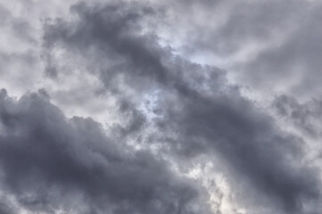 Fototapeta premium The round disk of the sun looks out through the gloomy clouds in the sky. Rainy weather. Stormy