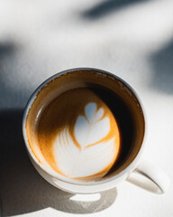 Cup of coffee latte on white table at coffee shop in morning time . Top view. Copy space.Coffee latte topview.