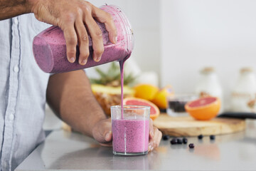 Trade your boring breakfast for a nutritional shake. Cropped shot of a man pouring a freshly...