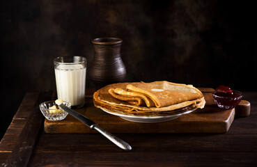 Pancakes, thin pancakes or crepes with jam on a white plate.