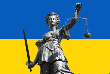 Die Justitia, das Symbol für Gerechtigkeit uind Justiz mit Schwert und Waage vor der ukrainischen Flagge