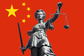 Fototapeta premium Die Justitia, das Symbol für Gerechtigkeit uind Justiz mit Schwert und Waage vor der chinesischen Flagge