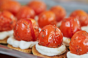 Appetizers with ricotta cheese and cherry tomatoes on serving tray