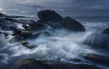 Beautiful long exposure shot of seascape at sunrise,silky smooth sea wave sweeping past the rock.