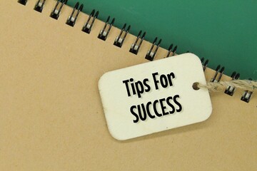 notebooks and wooden tags with the words tips for success