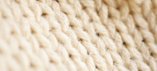closeup beige knitted woolen fabric texture background
