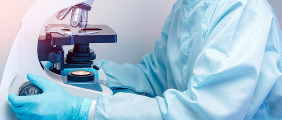 Banner microscope with metal lens at laboratory with hand of pharmacology worker. Concept industry...
