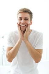 Young man checking his stubble in bathroom