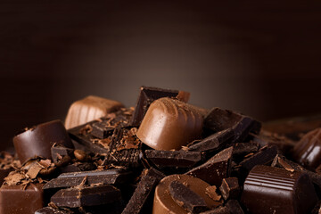 Chocolate candies and chocolate pieces pile for background