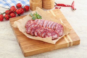 Sliced salami sausages over board