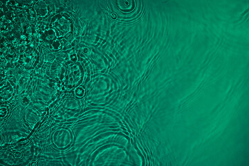 Fototapeta na wymiar Transparent dark green clear water surface texture with ripples, splashes and bubbles. Abstract nature background Water waves in sunlight with copy space Cosmetic moisturizer micellar toner emulsion