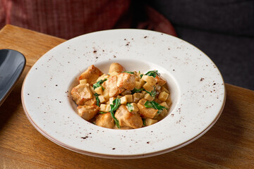 French cuisine a fricassee of Turkey with mushrooms, cream sauce on wooden table.