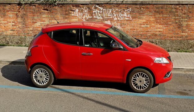 Udine, Italy. March 14, 2022. Red Lancia Ypsilon, city car of Fiat Group, on brick wall background.