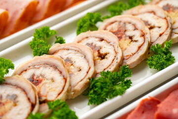 Platter of fresh meat cold cuts with vegetables.