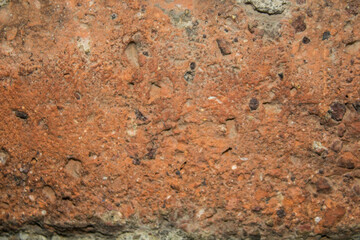 evocative close-up image of the surface of an orange brick 
