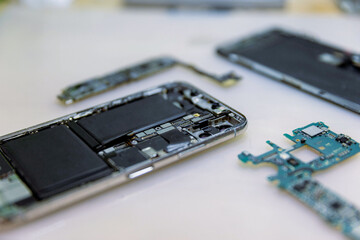 Phone repair concept several electronic devices taken apart into the components like the covers, circuit boards, bodies