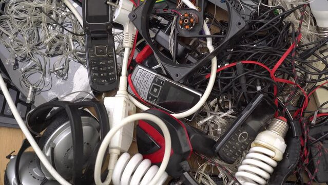 Electric scrap e-waste. Old wares, outdated mobile phones, non-working electronic devices, dead batteries, computer, pc, burned-out or broken lamps
