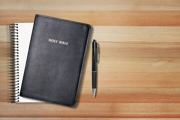 Holy bible with note book and pencil on table for christian devotion