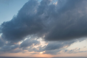 Cloudy evening sky. Sunset. Sun low over the horizon