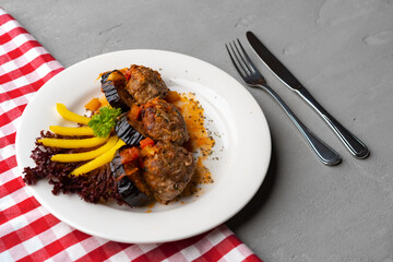 Cooked meat with fresh vegetable salad on a white plate