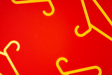 Hanger on red paper background. Minimalistic fashion concept. Top view
