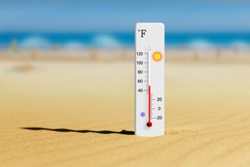 Sea coast at hot summer day. Fahrenheit scale thermometer in the sand shows plus 50 degrees