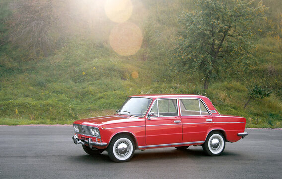 KYIV, UKRAINE-JULY 4, 2016: Red retro car VAZ-2103 "Zhiguli" parked on the road against the background of the forest. Space for text. Background with car. Background with car.